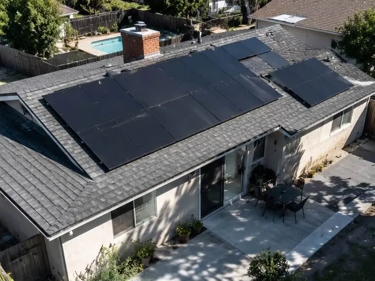 Solar array on a ranch-style home above a backyard patio